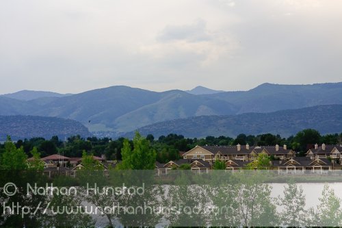 The Hogbacks behind houses on a lake at the Colorado Irish Festival